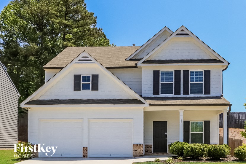 a white house with black window shutters and a garage
