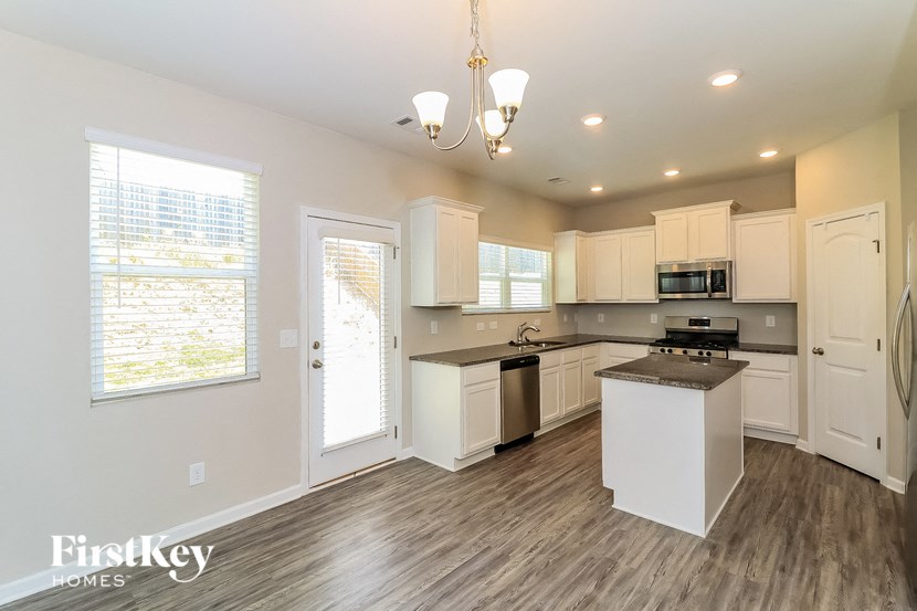 an empty kitchen with white cabinets and a counter top