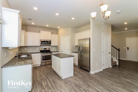 a kitchen with white cabinets and a stainless steel refrigerator