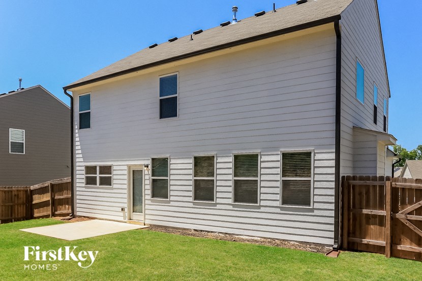 a white house with a yard and a wooden fence