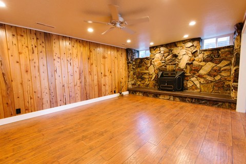 the living room of a house with wood floors and a stone wall
