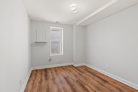 A room with wooden floors and a window.