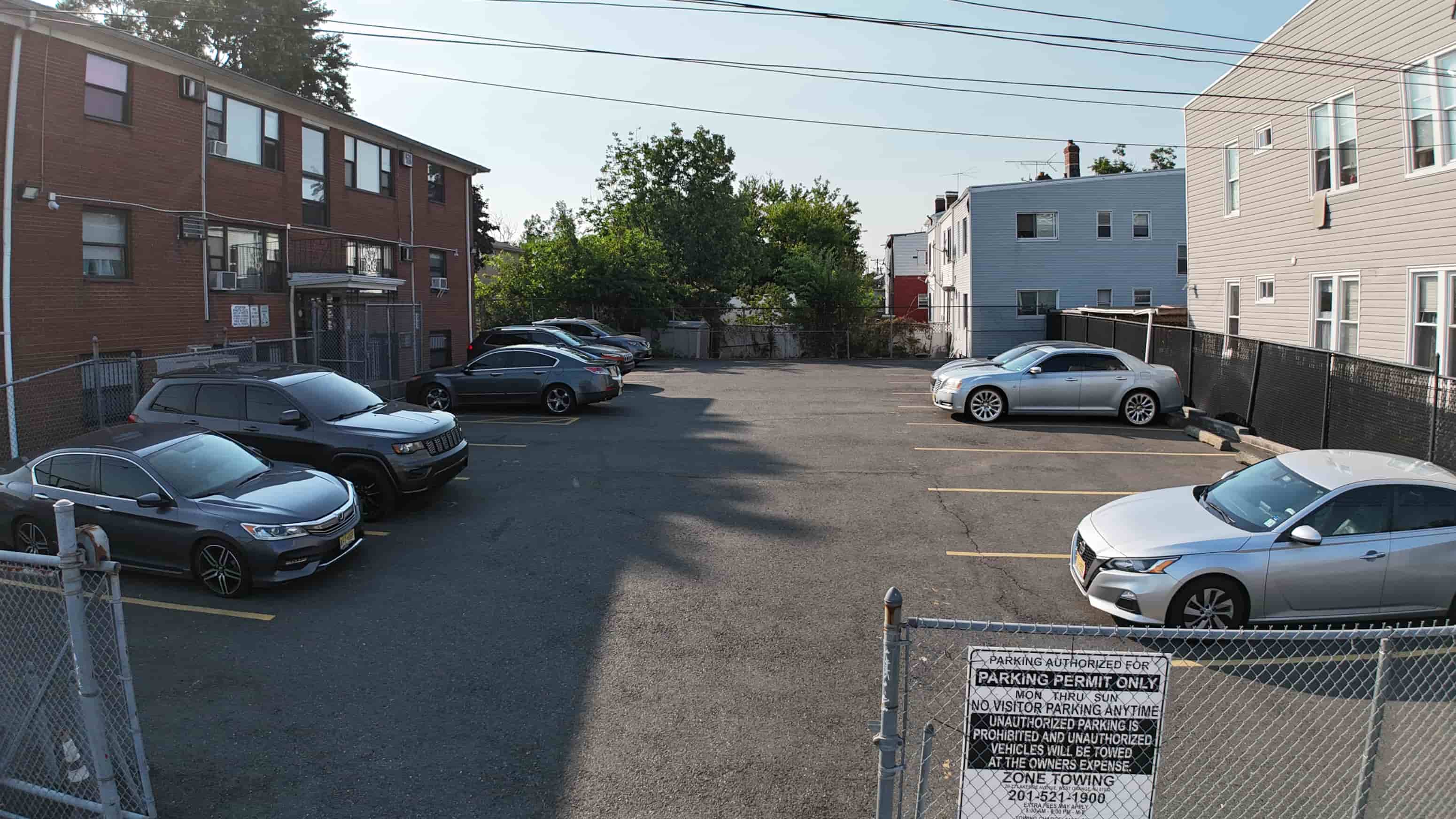 A parking lot with cars and a sign that says "No Parking Any Time".