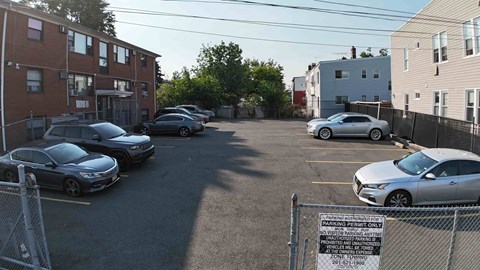 A parking lot with cars and a sign that says "No Parking Any Time".