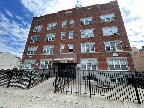 a tall brick building with a gate in front of it