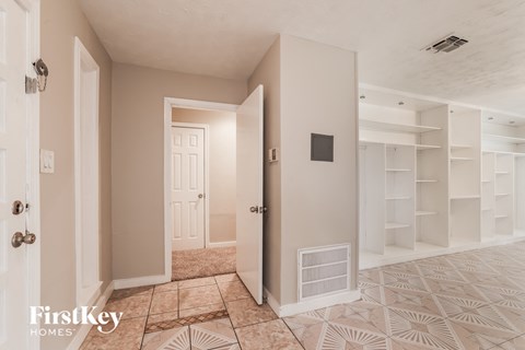 a walk in closet in a room with a tiled floor