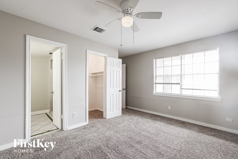 a bedroom with a ceiling fan and a closet