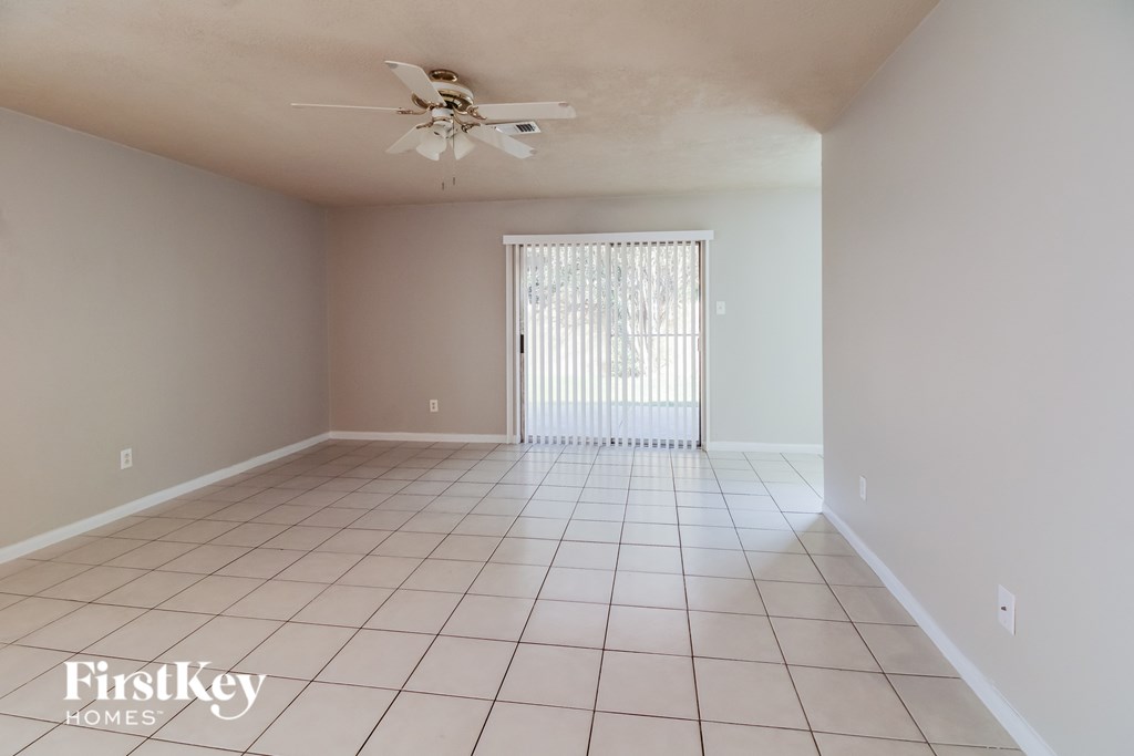 A spacious room with a fan and a sliding door.