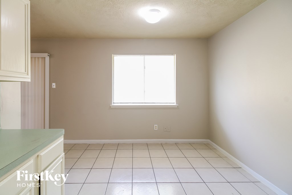 A room with a window and a tiled floor.