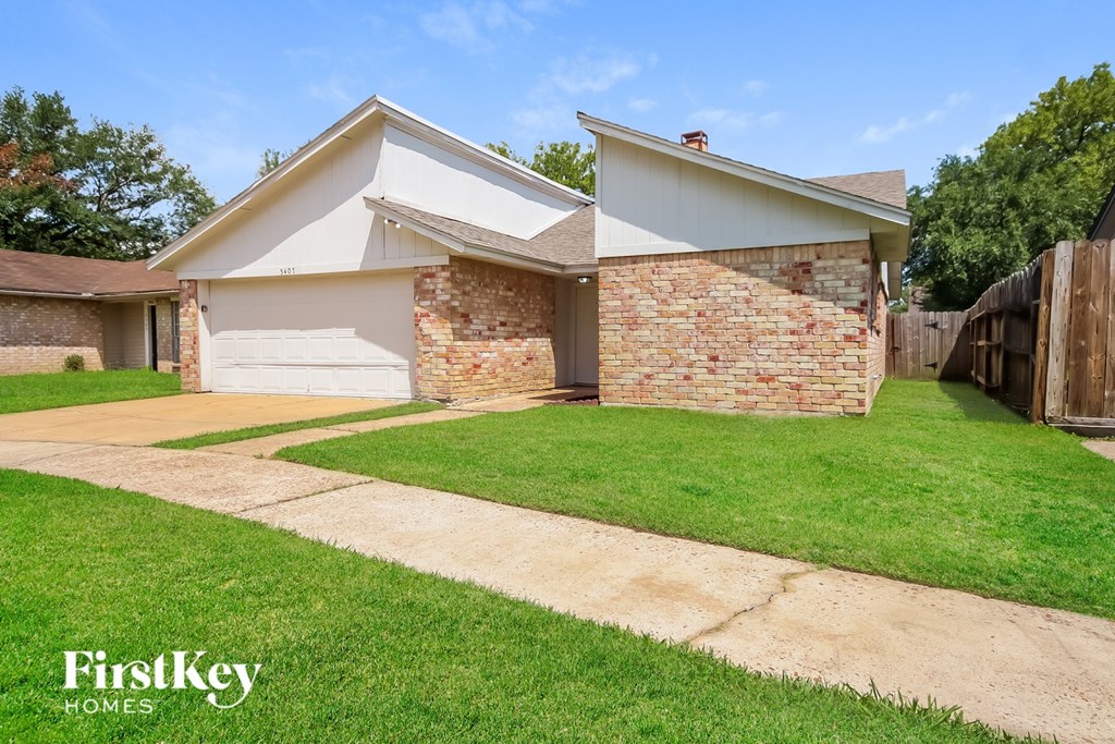 A house with a white garage door and a brick wall.