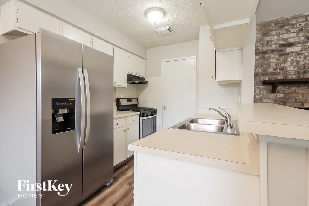 A kitchen with a stainless steel refrigerator and a white countertop.