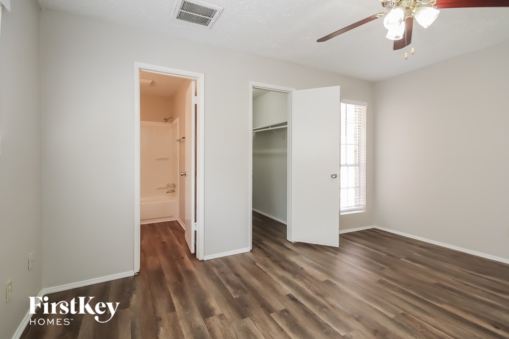 A room with a wooden floor and a ceiling fan.