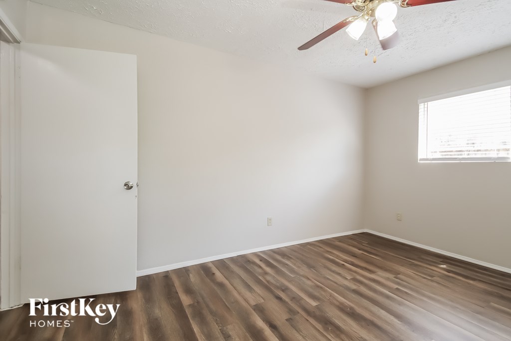 A room with a wooden floor and a ceiling fan.