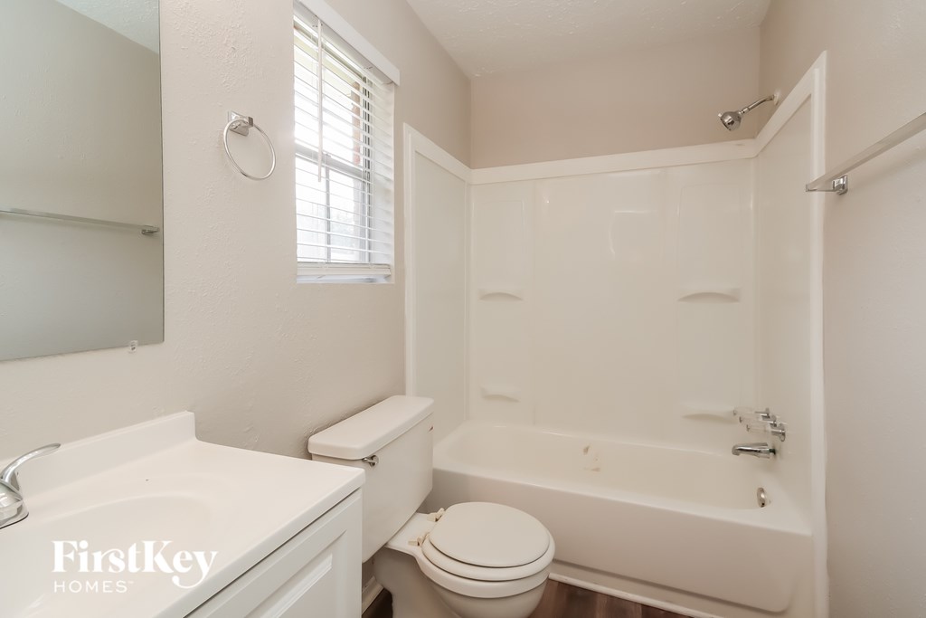 A white bathroom with a toilet, sink, and bathtub.