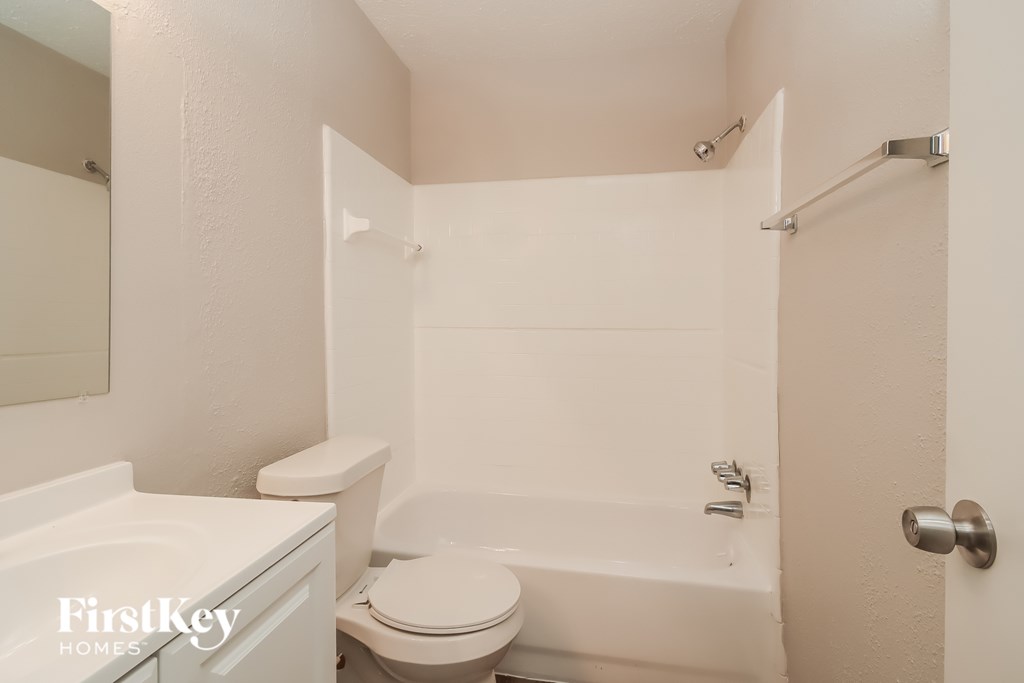 A white bathroom with a toilet, sink, and bathtub.