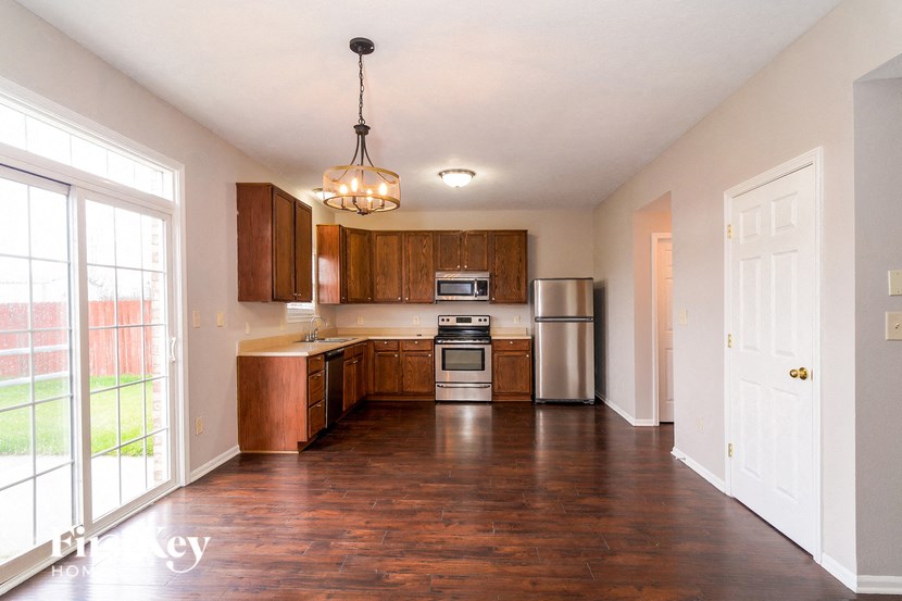 an empty kitchen with wooden cabinets and stainless steel appliances