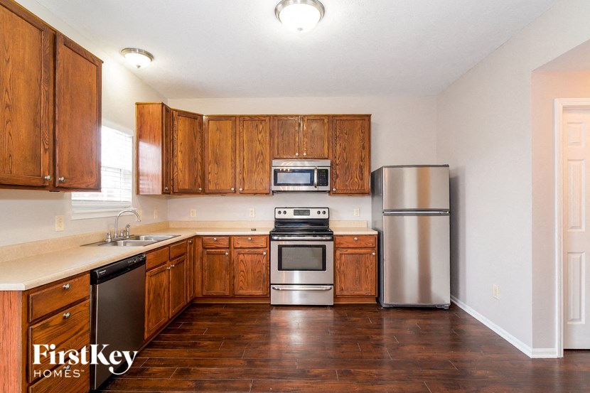 a kitchen with wooden cabinets and stainless steel appliances