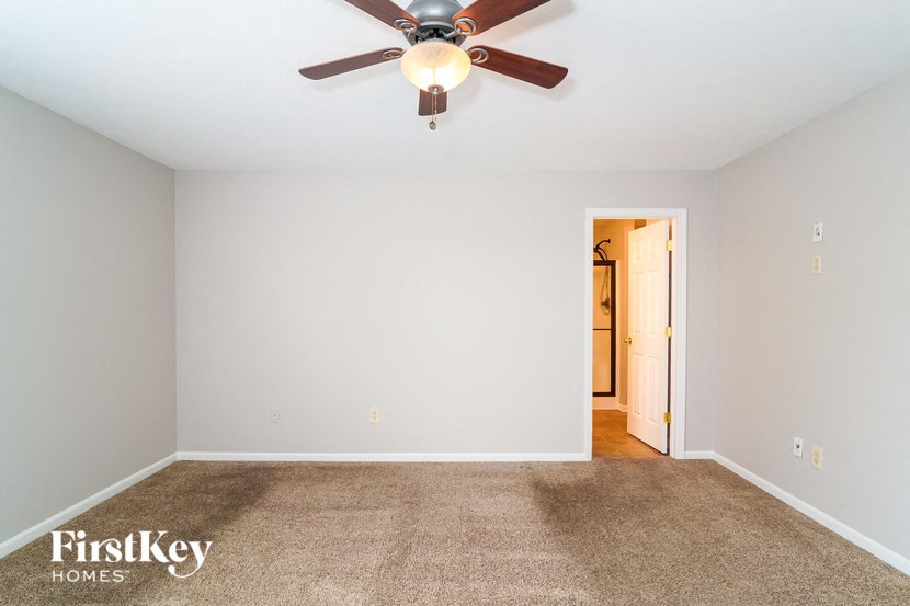 a living room with carpet and a ceiling fan