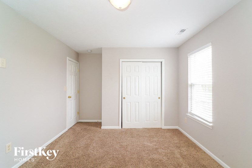 a bedroom with a carpeted floor and a white door