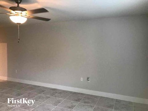 a living room with a ceiling fan and a tiled floor