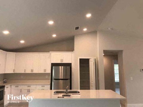 a kitchen with white cabinets and a sink and a refrigerator