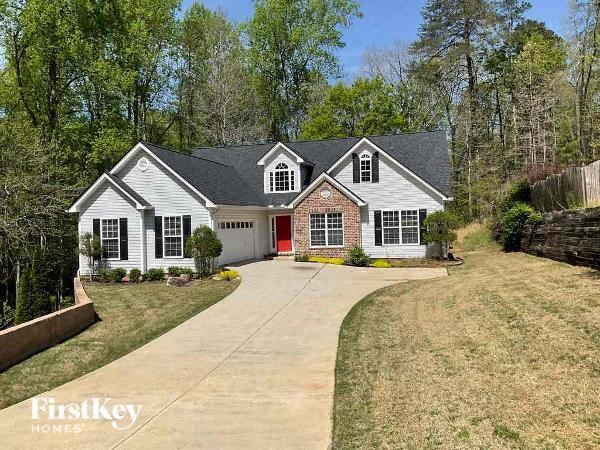 a white house with a red door and a driveway
