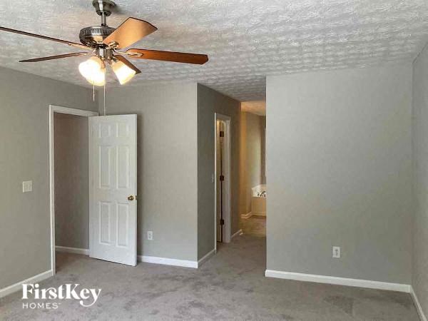 an empty room with a ceiling fan and a door
