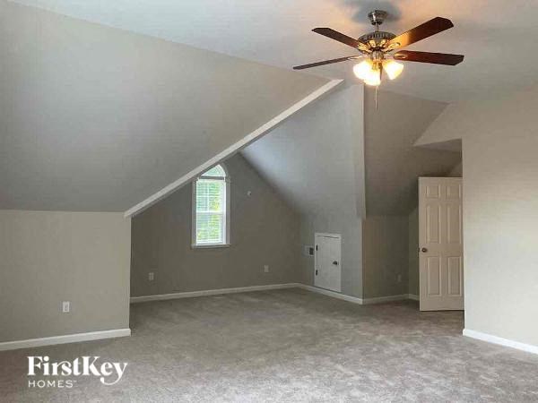 an empty bedroom with a ceiling fan and a door