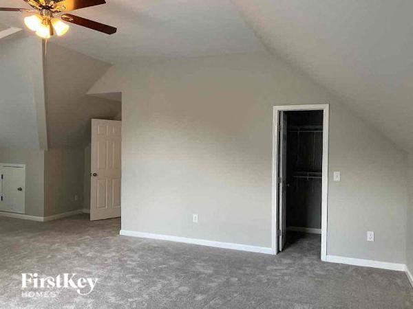 an empty living room with a ceiling fan and a door