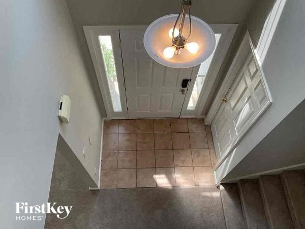 a hallway with a white door and a ceiling light