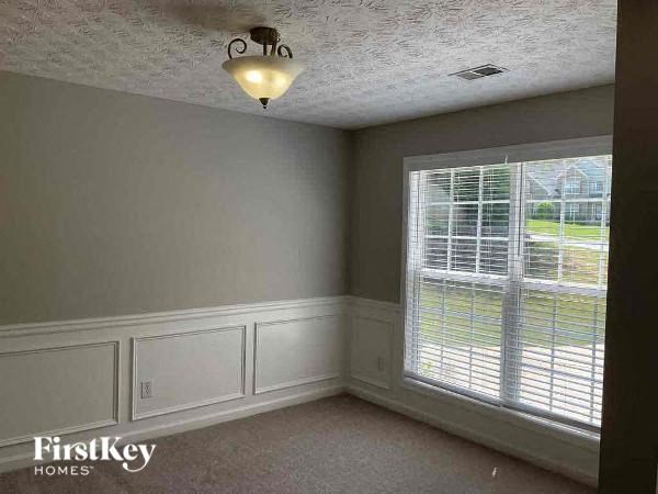 an empty bedroom with a large window and a light on the ceiling