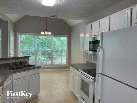 a white kitchen with a refrigerator and a sink