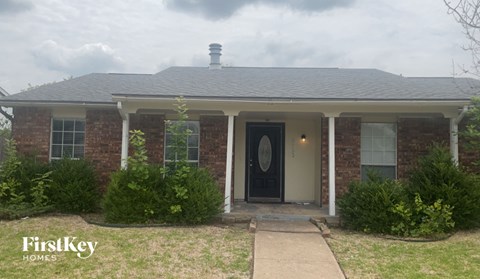 A brick house with a black door and a sign that says "FirstKey Homes".