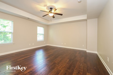 A room with wooden floors and a ceiling fan.