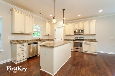 A kitchen with wooden floors and a center island.
