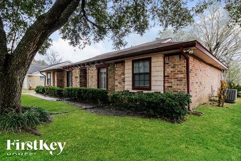 a brick house with a tree in the yard