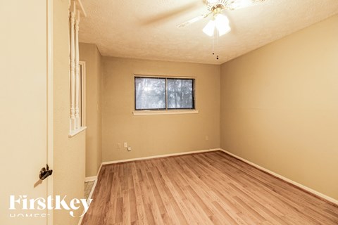 the living room of an empty house with wood floors and a window