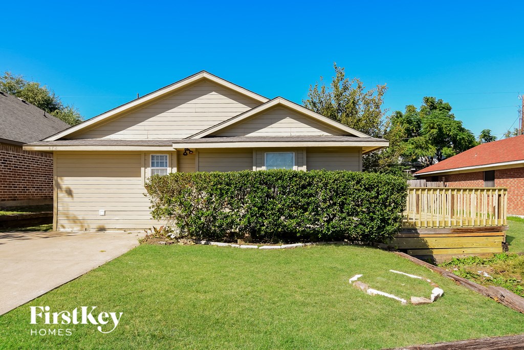 A house with a well-kept lawn and a wooden fence.