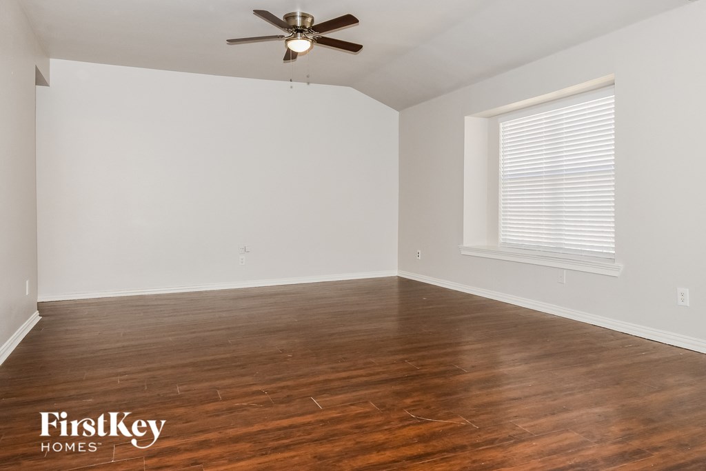 A room with wooden floors and a ceiling fan.