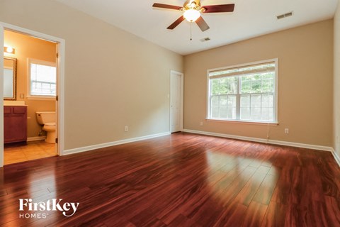 the living room with hardwood flooring and a ceiling fan