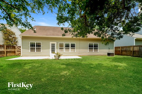 a white house with a grassy yard and a wood fence