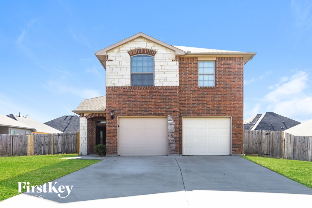 A brick house with a garage door and a window.