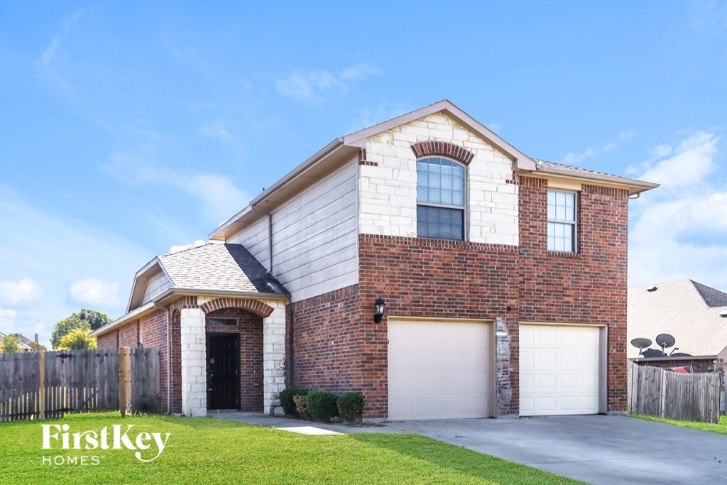 A brick house with a garage door and a window.