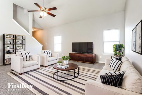 A living room with a striped rug and a television.