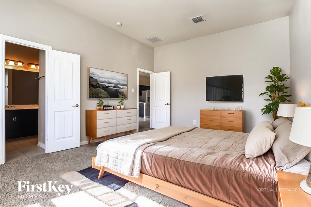 A bedroom with a bed, dresser, and a painting on the wall.