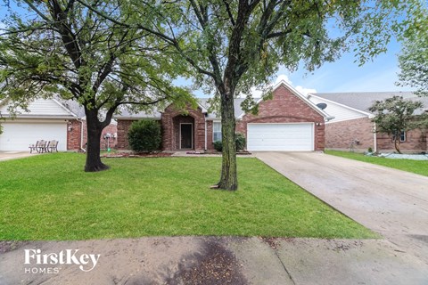 a house with a lawn and trees in front of it