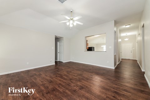 a living room with a hard wood floor and a ceiling fan