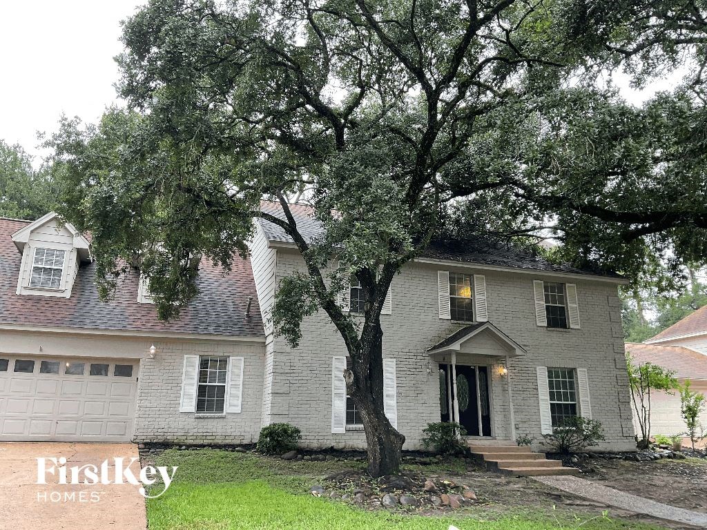 a white house with a large tree in front of it