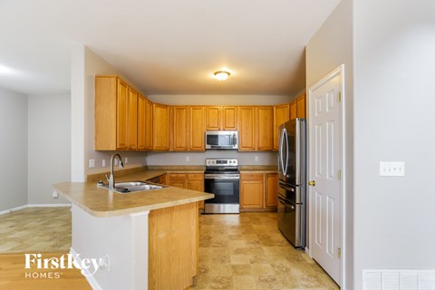 A kitchen with wooden cabinets and a white fridge.