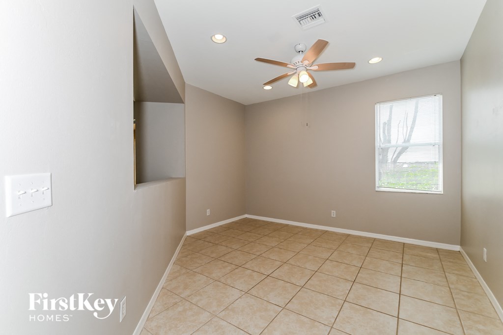 a living room with a ceiling fan and a tiled floor
